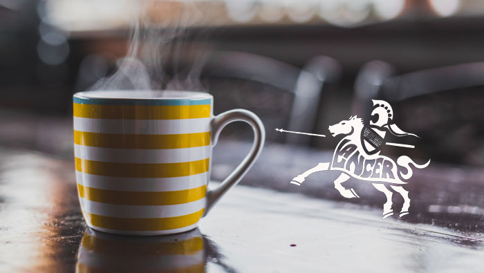 Steaming cup of coffee with the Niu Valley lancer logo