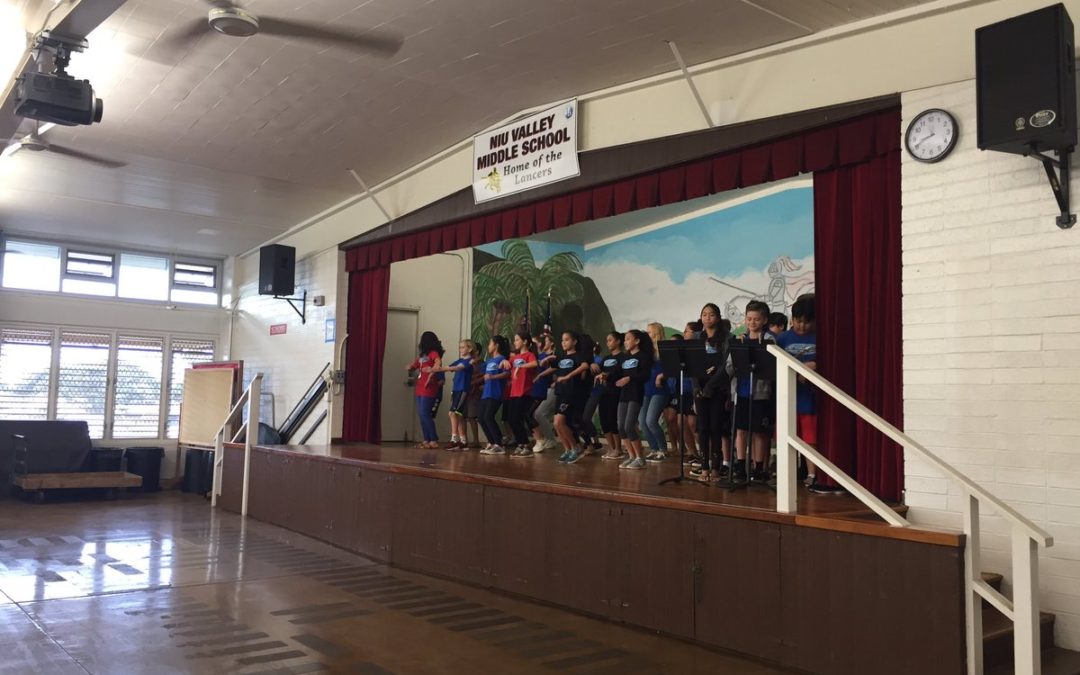 Students dance hula on cafeteria stage