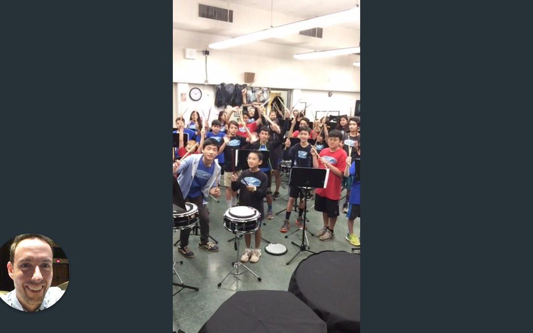 Computer screen shot of percussion classroom with students holding drumstick; teacher in circle in lower left corner