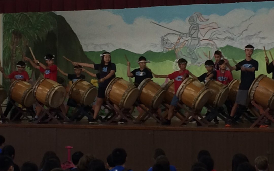 Group of students on stage playing the taiko drums