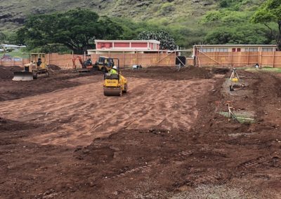 Dirt Worksite Grading of the World Language Center with three construction vehicles