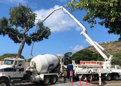 White cement mixer truck and concrete pump in parking lot