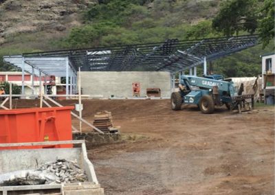 Construction site with dirt ground and partial built classrooms