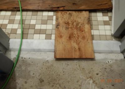 wooden plank across threshold to tiled restroom