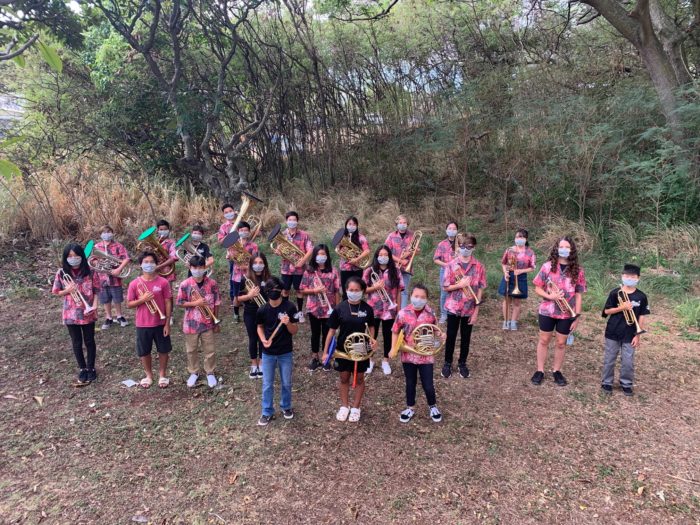 Group of students in the field holding wind and percussion instruments