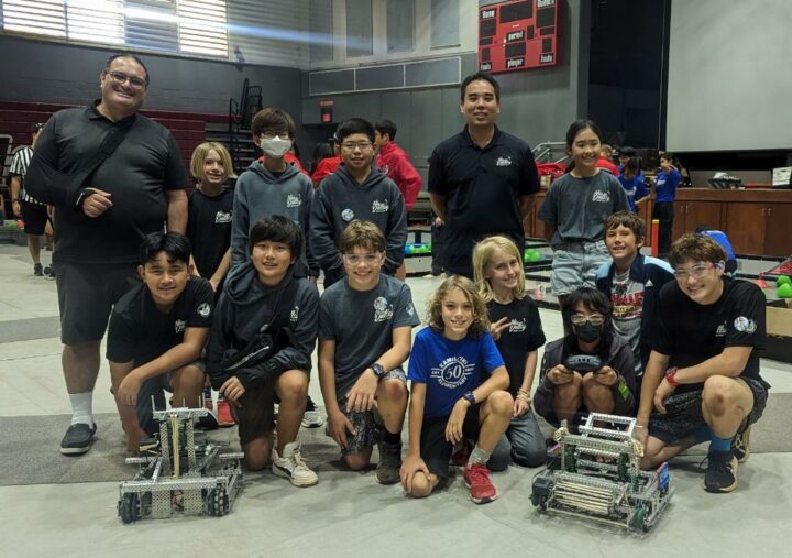 Group of students and adults at a Robotics Competition